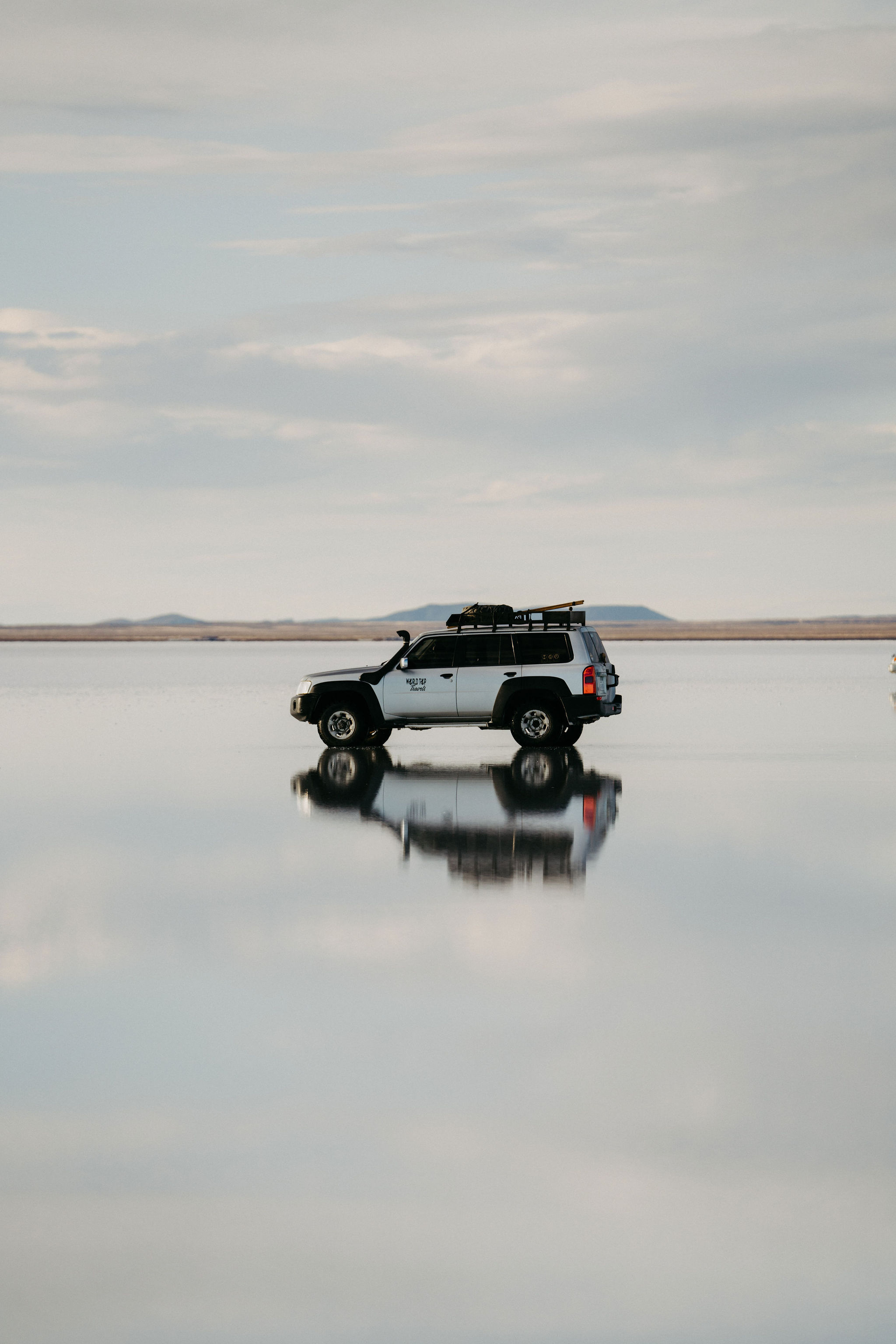 Jeep reflected in the flooded mirror surface of the Salar de Uyuni