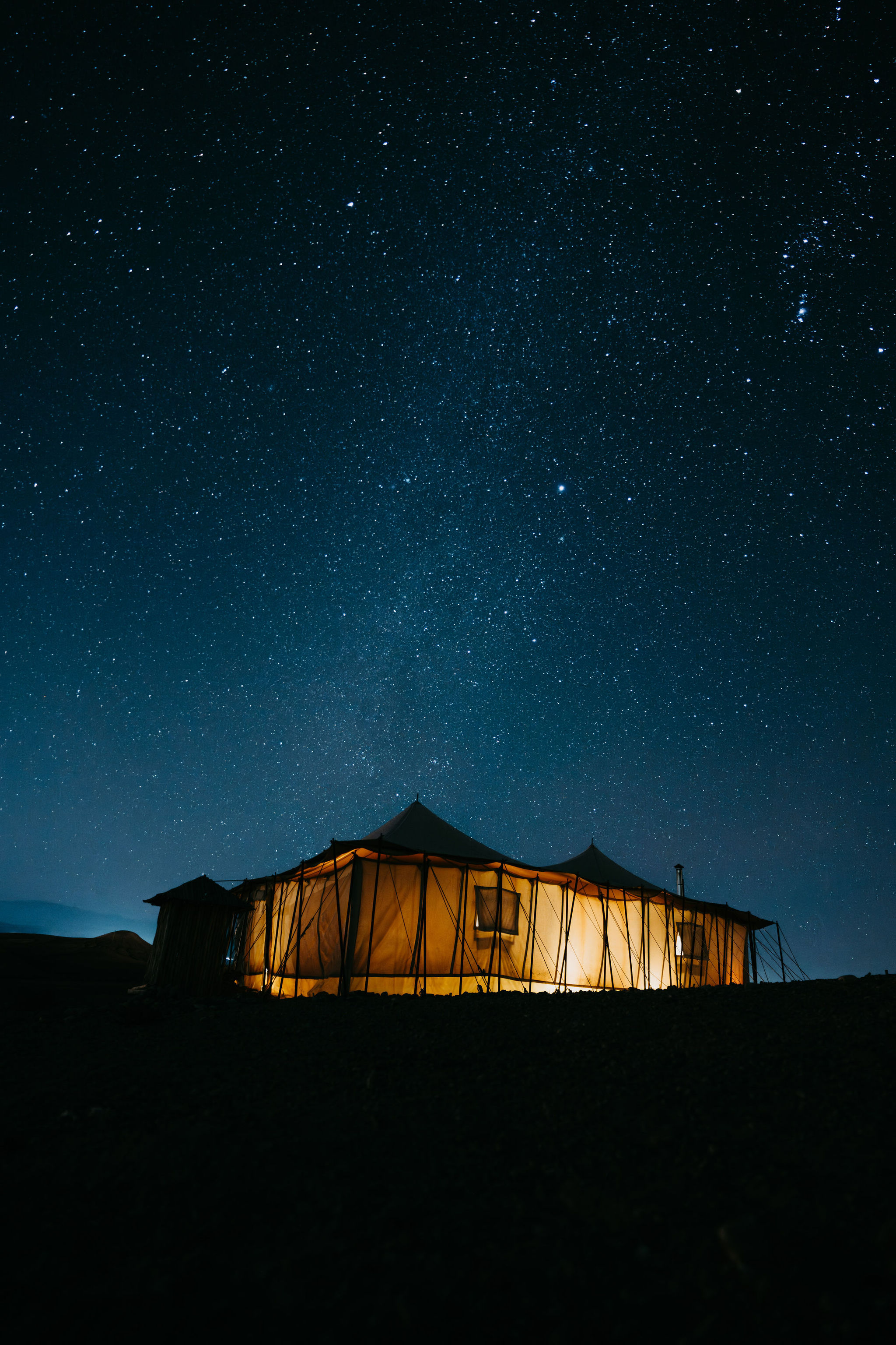 Desert camp lounge lit by lanterns at night