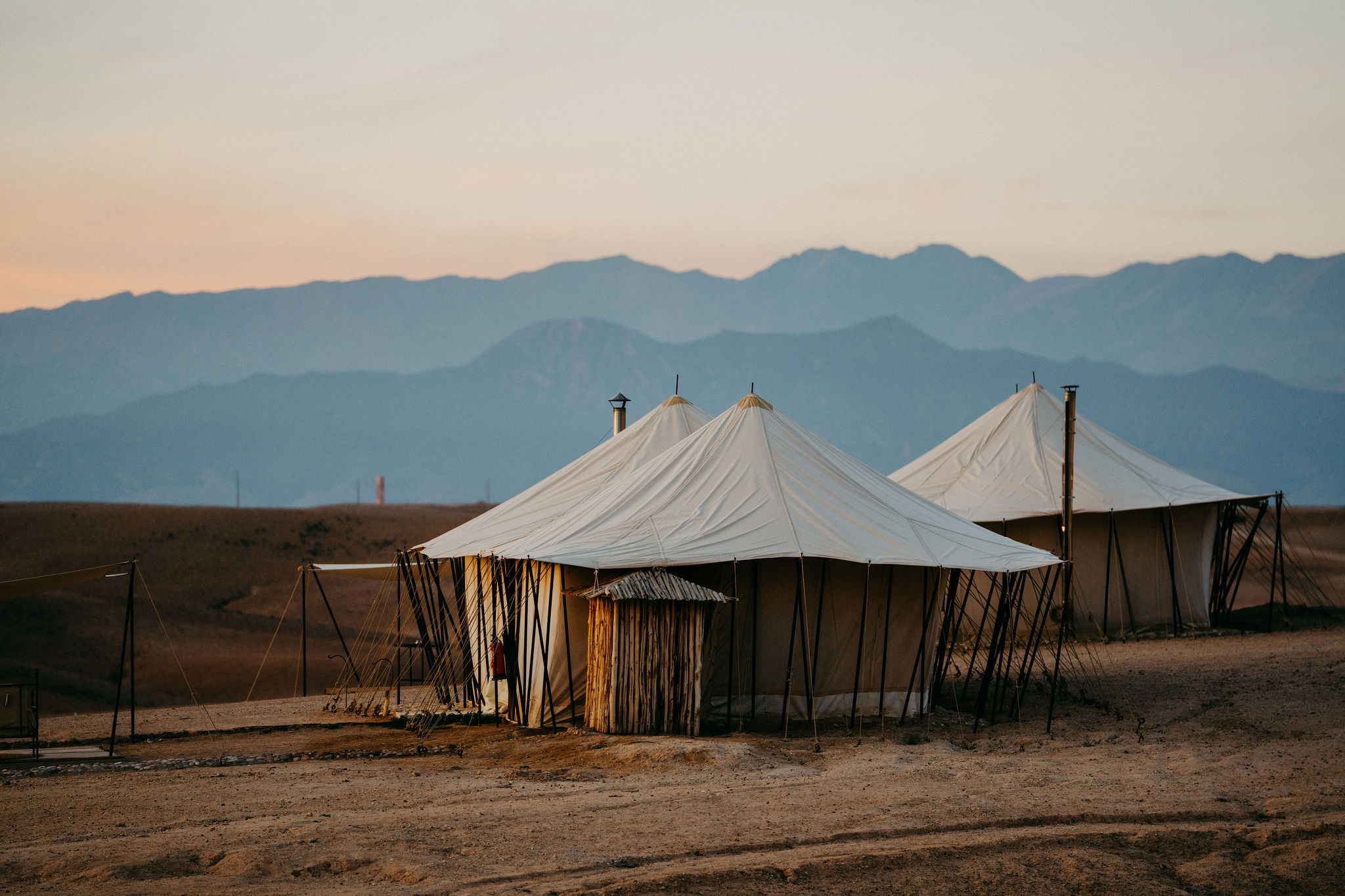 The tents of Scarabeo Camp on the Agafay desert plateau at sunset